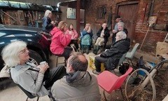 Group drinking tea in barn at John Scott's Farm.